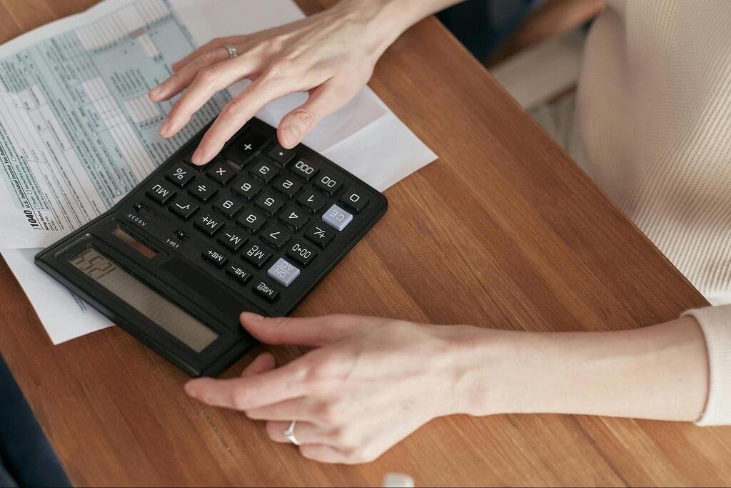 kobieta licząca coś na kalkulatorze